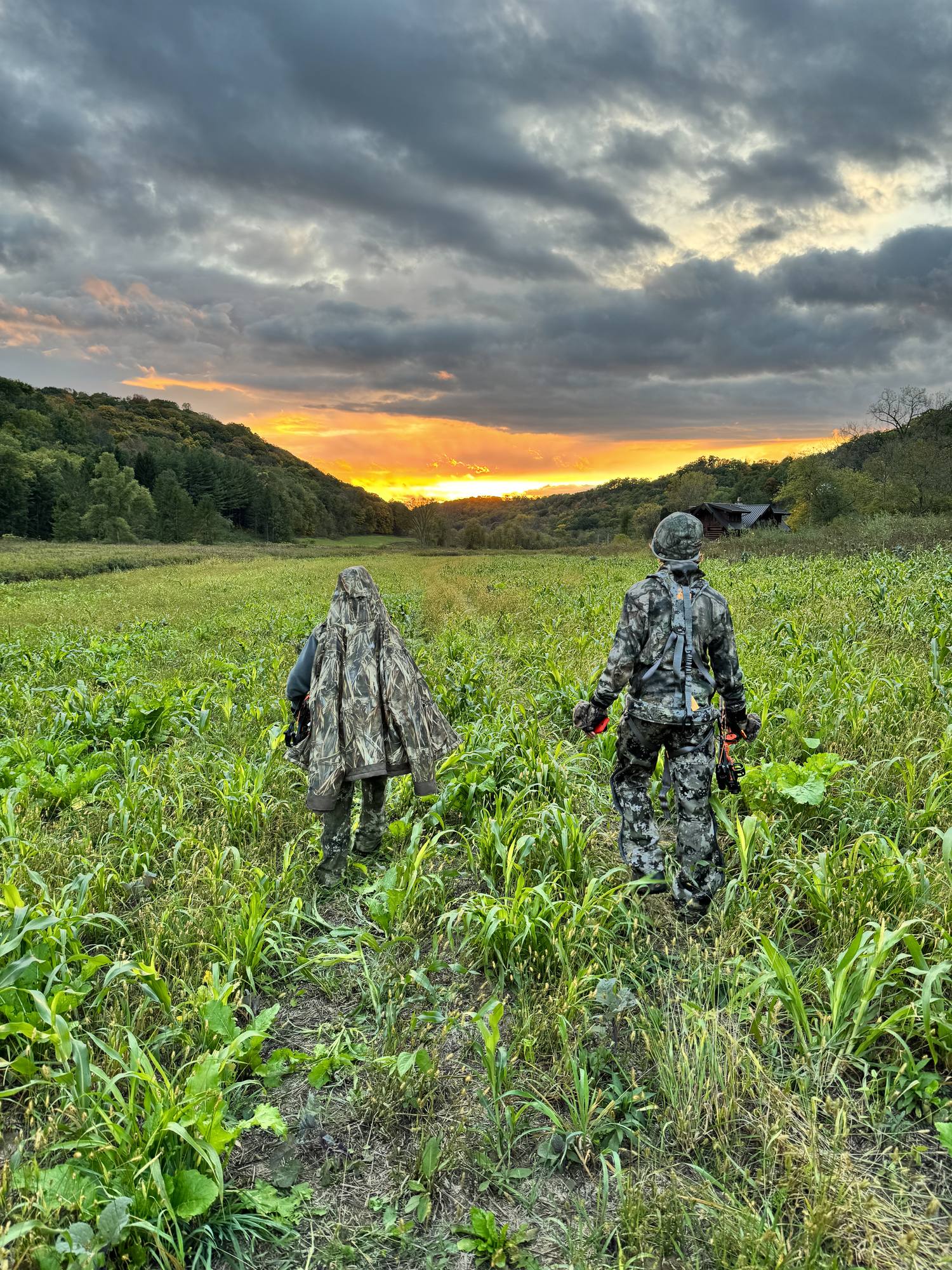 Two children walking into the valley at sunset